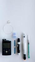 Diabetes management devices, insulin pump, glucometer, injection, and syringe on white background photo