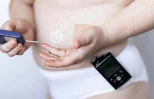 Diabetes management at home, person using glucometer and insulin pump photo