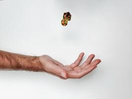 Hand tossing colorful dice against white background capturing motion photo