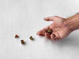 Hand holding colorful polyhedral dice on white surface for tabletop gaming photo
