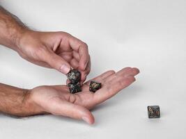 Hands holding polyhedral dice for dungeons and dragons game session photo