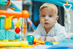 A baby plays on a developmental mat for two months. Toy rug for small children. photo