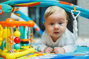A baby plays on a developmental mat for two months. Toy rug for small children. photo