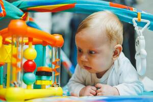A baby plays on a developmental mat for two months. Toy rug for small children. photo