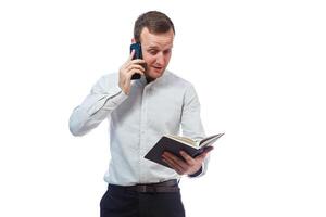 man businessman, teacher, mentor examines entries in your diary and talking on a cell phone. Isolated on white background photo