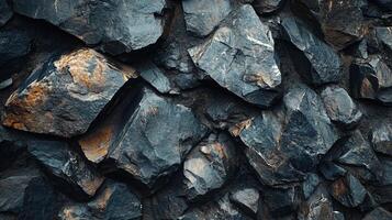 Close up of a rock wall with a brownish orange tint. The rocks are of various sizes and shapes, and the wall appears to be made of granite. Scene is one of ruggedness and strength photo