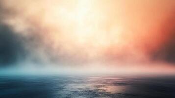 Blurry image of a foggy, misty day with a bright orange and blue sky. The sky is filled with clouds, and the water is calm. Scene is serene and peaceful, with the water photo