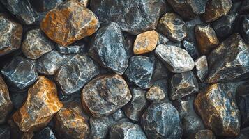 Pile of rocks with some orange and brown ones. The rocks are all different sizes and shapes photo