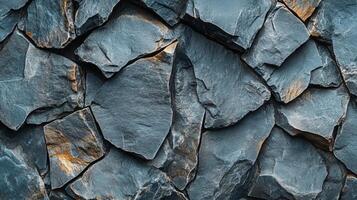Close up of a rock wall with a lot of cracks and crevices. The wall is made of stone and he is quite old. The cracks and crevices give the wall a rugged and weathered appearance photo