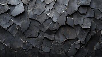 Black and white photo of a wall made of broken pieces of stone. The photo has a moody and somber feel to it, as the broken pieces of stone create a sense of disarray and chaos