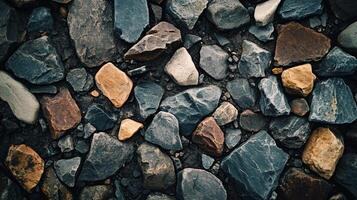 Close up of a pile of rocks with a variety of colors. The rocks are scattered and piled up in different sizes and shapes. Concept of ruggedness and natural beauty photo