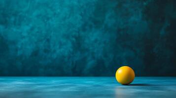 Single orange sits on a blue surface. The orange is the only object in the image, and it is the main focus. The blue background creates a calm and serene atmosphere photo