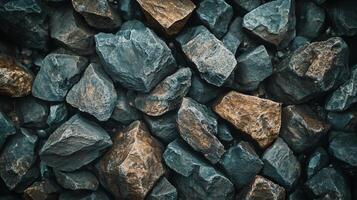 Close up of a pile of rocks with a blue and brown color scheme. The rocks are of various sizes and shapes, and they appear to be rough and jagged. Scene is rugged and natural photo