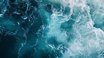 Large body of water with waves crashing against the shore. The water is a deep blue color, and the waves are white and choppy photo