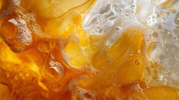 Close up of a yellow liquid with bubbles in it. The bubbles are scattered throughout the liquid, giving it a frothy appearance. The liquid seems to be a mixture of different colors photo