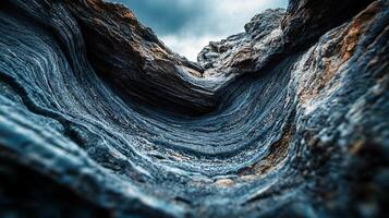 The image is of a rocky cliff with a blue and white color scheme. The rocks are jagged and rough, giving the impression of a harsh and unforgiving environment photo
