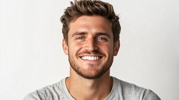 Man with a beard and a smile on his face. He is wearing a gray shirt. Concept of happiness and positivity photo