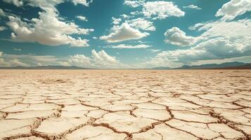 Desolate desert landscape with a clear blue sky. The sky is dotted with clouds, and the sun is shining brightly. The emptiness of the desert and the clear blue sky create a sense of loneliness photo