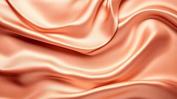 Piece of orange fabric with a pattern on it. The fabric is folded and has a shiny appearance photo