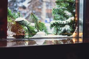 a Christmas window sill on which you can put something. there is a fir tree garland and snow outside the window. High quality photo