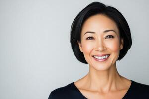 Smiling woman with short black hair posing against a light background photo