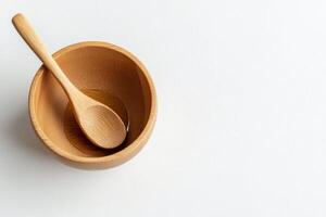 Wooden bowl with spoon on a plain background for culinary presentation photo