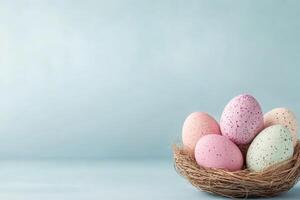 Colorful speckled eggs arranged in a nest on a soft blue background for a festive celebration photo