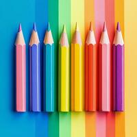 Colorful pencils arranged on a vibrant rainbow background in a creative workspace photo