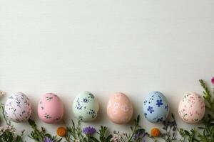 Decorative Easter eggs with floral designs arranged on a light surface with greenery photo