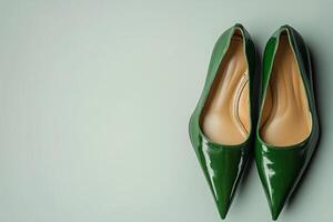 Elegant green high heels presented on a smooth pastel surface for fashion enthusiasts photo