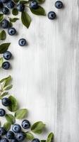 Blueberries on a rustic wooden surface with a light blue background photo