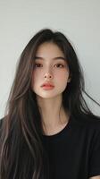 Portrait of a woman with long dark hair and striking features in a simple black top photo