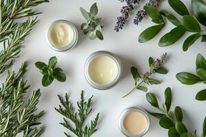 Collection of skincare products arranged on a white surface with green leaves photo
