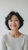 Woman with short black hair smiling warmly in a relaxed indoor setting during daylight photo