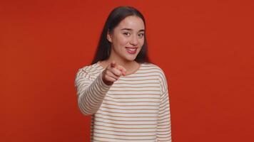 Woman pointing to camera, looking with playful happy expression, making choice, showing direction video
