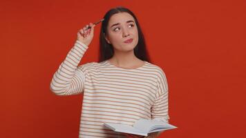 Thoughtful journalist woman making notes, writing down thoughts with pen into notepad notebook diary video