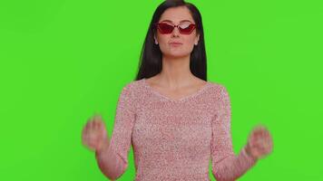 Happy young pretty woman wearing sunglasses, looking at camera with toothy charming smile, flirting video