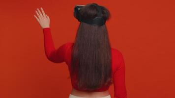 Young woman using virtual reality headset helmet to play simulation game app, watching content video
