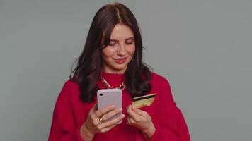 Young woman using credit bank card and smartphone while transferring money purchases online shopping video
