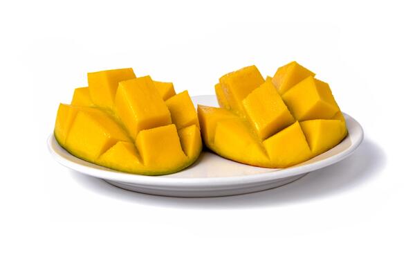 Ripe mangos sliced cut to cubes on a white background, top-side view