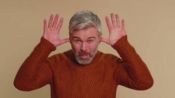 Funny joyful man making playful silly facial expressions, grimacing, fooling around showing tongue video