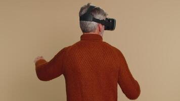 Senior man using virtual reality headset helmet to play simulation game app, watching content video