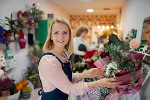 Joyful florist arranging beautiful flower bouquets in a charming shop setting photo