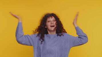 Curly haired woman appear from below waving hi with her palm greeting with hospitable friendly smile video