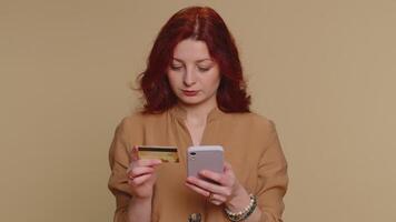 Young woman using credit bank card and smartphone while transferring money purchases online shopping video