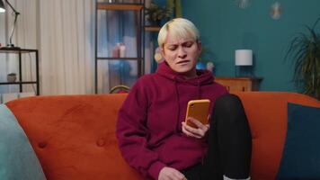 Sad young woman use smartphone surprised by bad news, fortune loss, fail, lottery results, deadline video