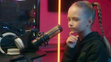 Pensive puzzled hesitate little Caucasian girl teenager gamer streamer child kid daughter using computer neon home thinking solution virtual game addiction streaming microphone come up with idea happy video