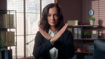 Serious Caucasian woman showing gesture hands crossed refusal stop female girl businesswoman shaking head negative business office forbid deny no never not sign crossing arms indoors reject manager video