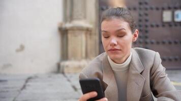 A young professional is totally engrossed in using their smartphone while in an urban setting video