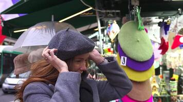 Tourist Browsing Colorful Hats at Parisian Market video